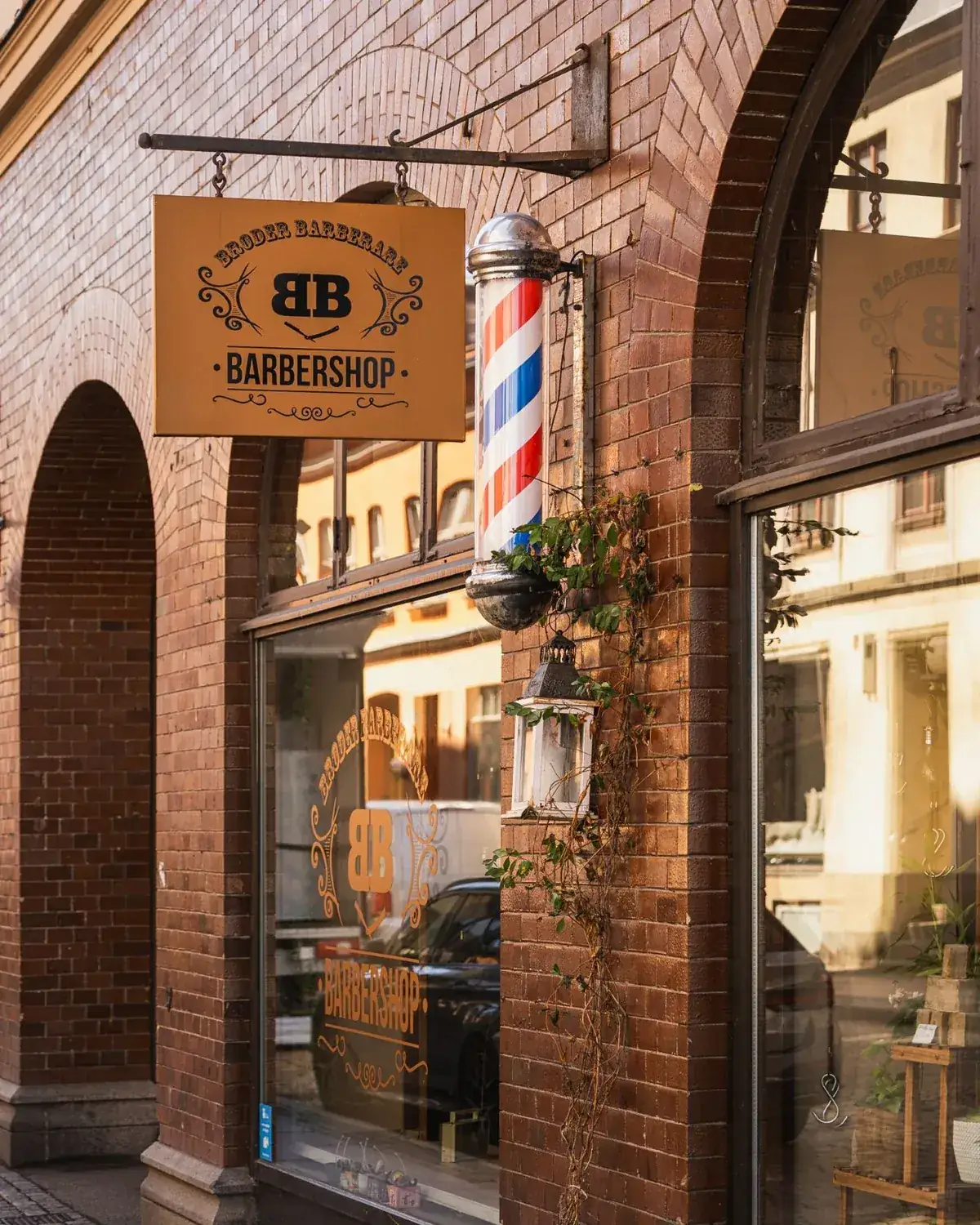 Exterior sign and barber pole outside a Malmö barbershop