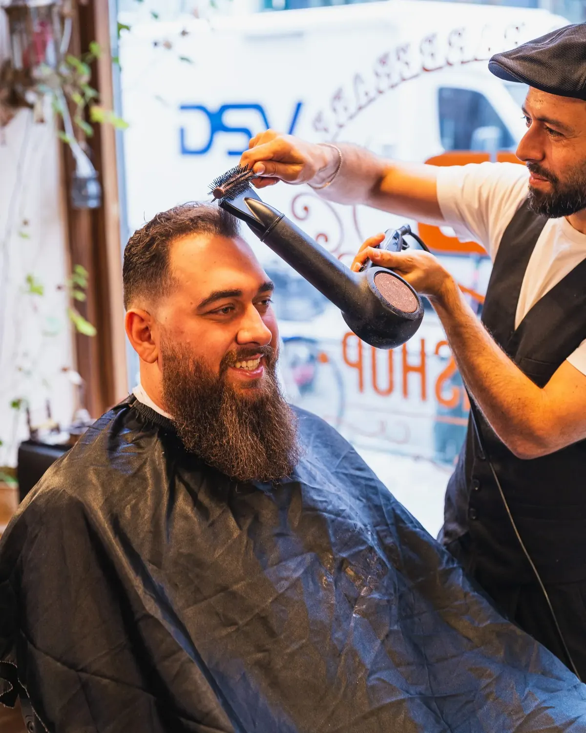 A barber trimming a client's hair from behind