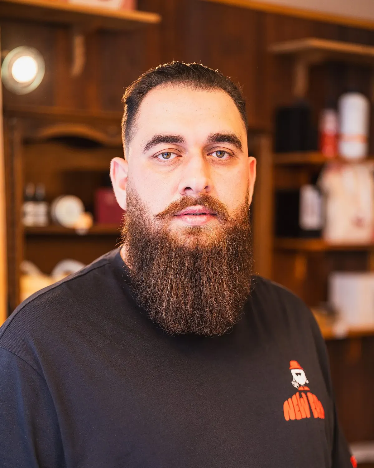 Finished portrait of a client with a full trimmed beard, looking at the camera