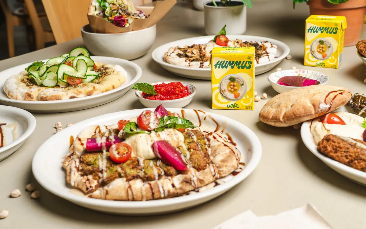 A spread of flatbreads, pita, and dips across several plates at Hummusson