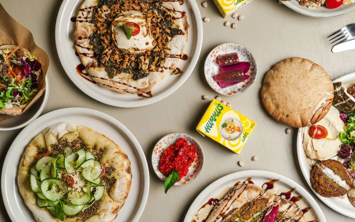 Overhead view of flatbreads, dips, and pita bread on a table